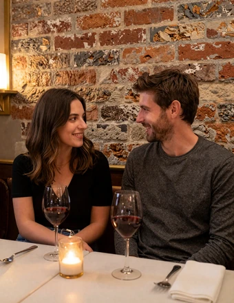 Couple enjoying intimate conversation at a candlelit Parisian bistro with wine glasses