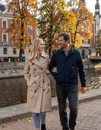 Couple walking along the Daugava River in Riga with autumn golden leaves and Art Nouveau buildings