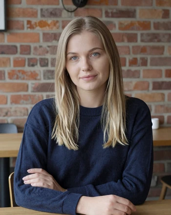 Līga, 27, Latvian woman from Riga sitting at a cozy cafe with a warm gentle smile