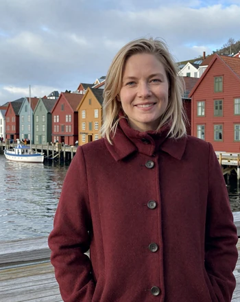 Maren, 34, verified Norwegian woman from Bergen smiling near the colorful harbor houses