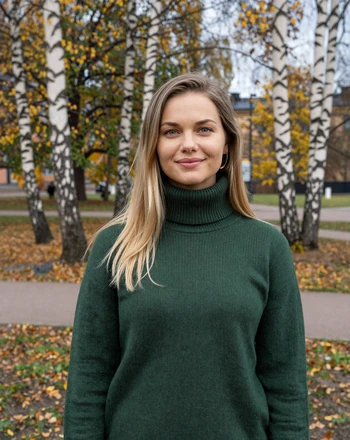 Aino, 33, Finnish woman from Helsinki with thoughtful smile in a park surrounded by birch trees