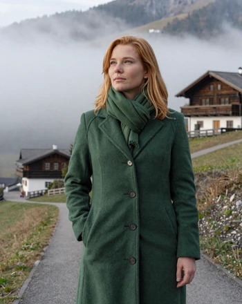 Annika, 30, Liechtenstein woman from Triesenberg on a misty hillside path near a traditional Walser chalet