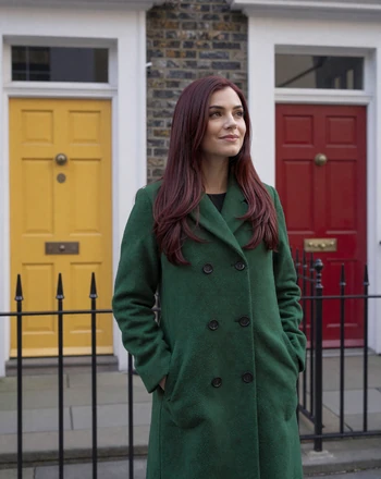 Roisin, 32, Irish woman from Dublin standing on a Georgian doorstep with colorful doors