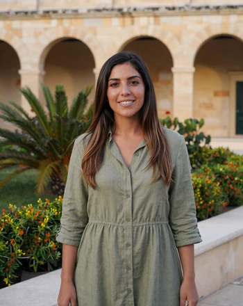 Antoinette, 30, Maltese woman in the Upper Barrakka Gardens Valletta with arched colonnade behind
