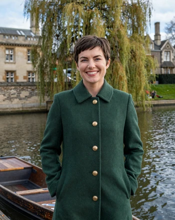 Amelia, 30, British woman from Cambridge beside the river with historic college buildings